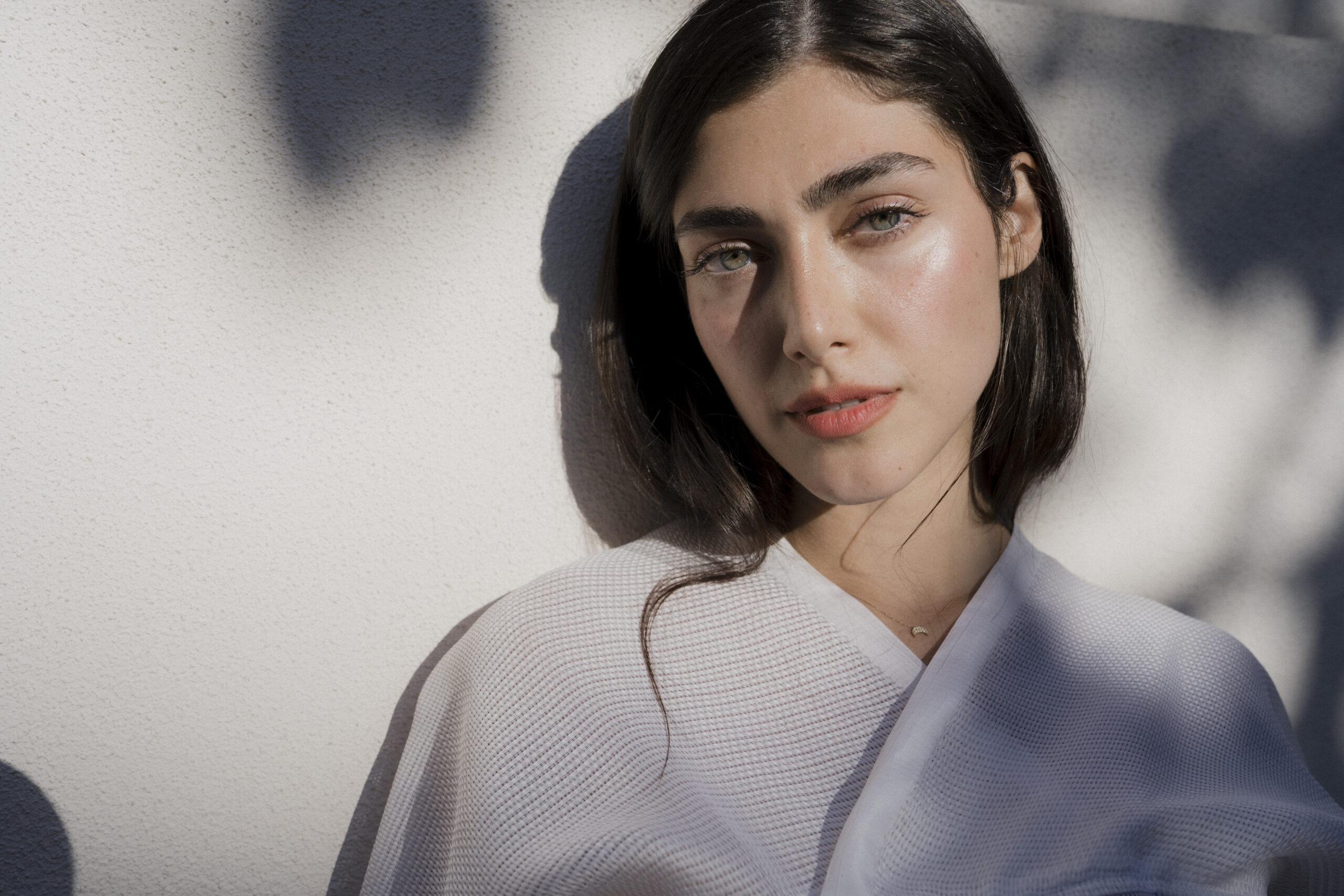 Sedcardshooting-München-1 Sedcard-Porträt einer Frau im weißen Oberteil im weichen Abendlicht bei Sonnenschein.